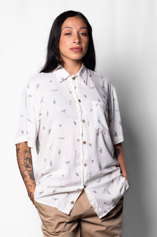 Camisa Oversize Chido de corte oversize confeccionada en rayón, un tejido ligero y fresco que garantiza comodidad. Presenta un diseño blanco con estampados minimalistas de cactus y elementos botánicos que evocan la cultura mexicana y un estilo relajado y auténtico. Los botones en coco le aportan un toque natural y elegante, mientras que su silueta amplia es ideal para un look casual y moderno.